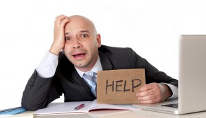 bald latin business man over worked holding a help sign